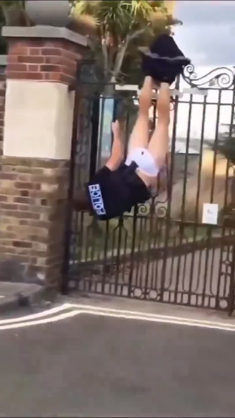 Figure in POLICE Gear Left Dangling Upside Down on a Gate