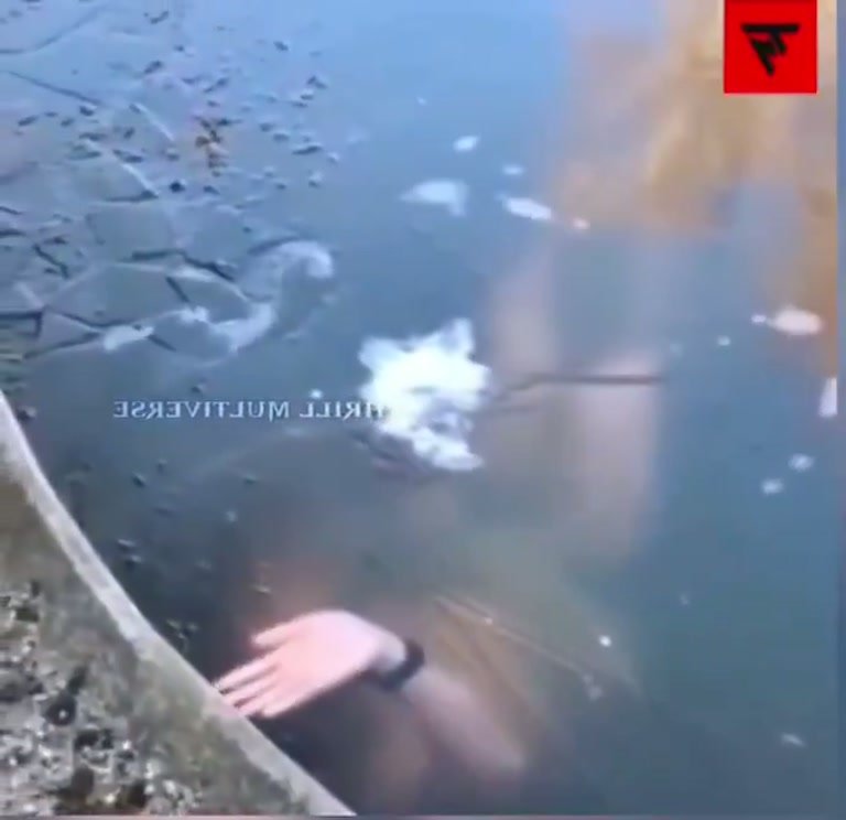 A Hand Presses Against the Ice From Below in Freezing Water