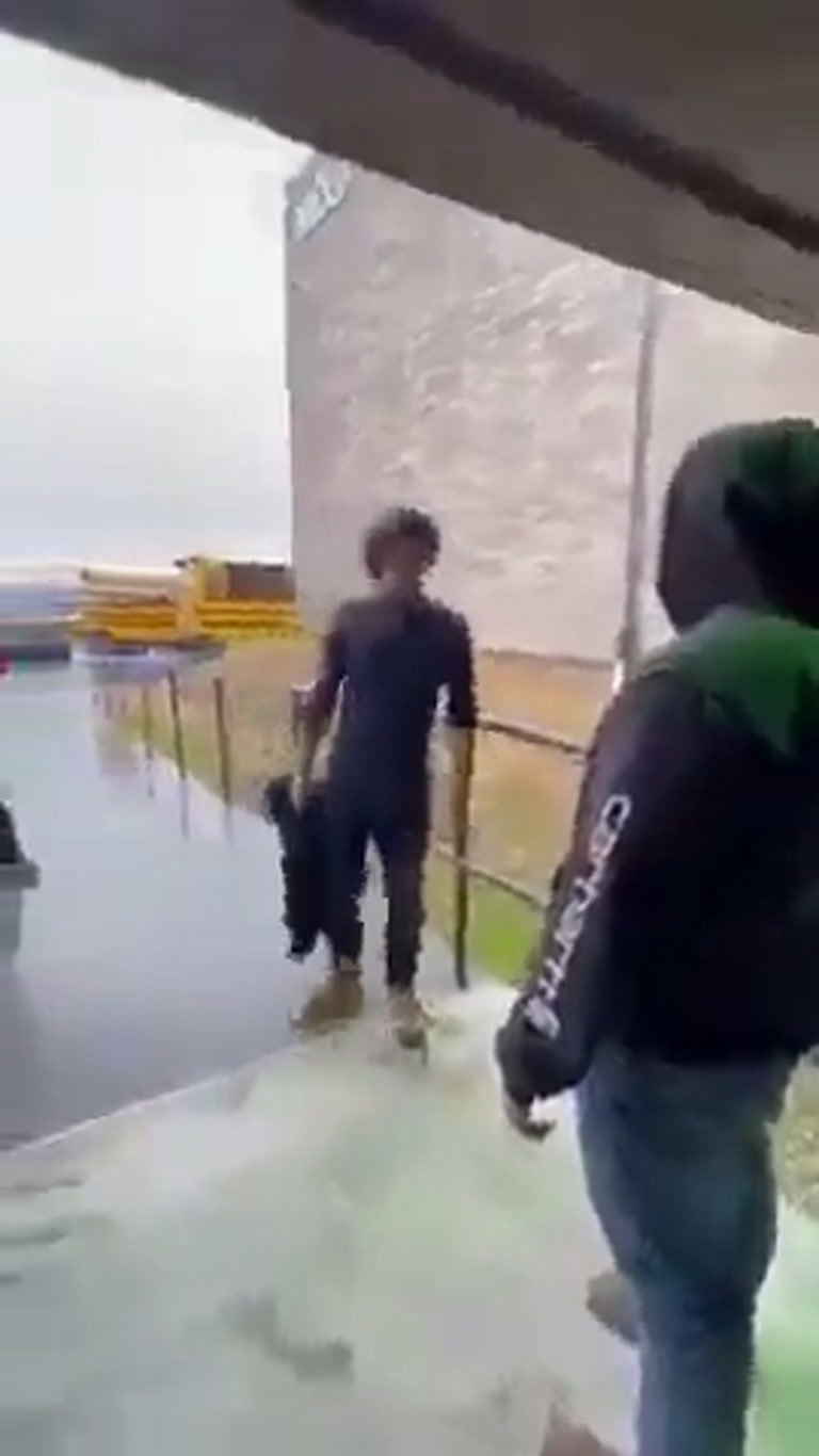 Outside a School, Two Students Square Off as a Bus Waits