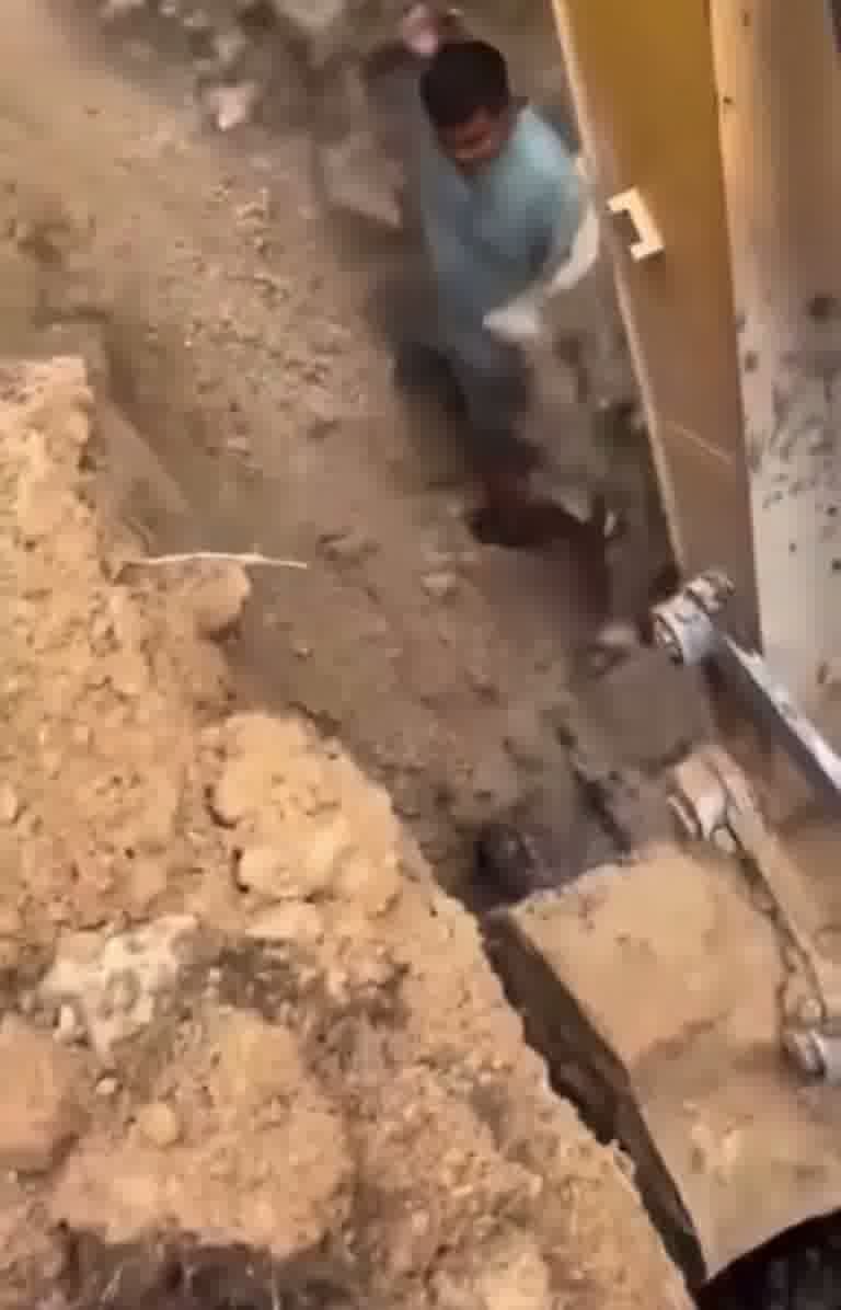Worker Rides Excavator Bucket Into Deep Pit as Crew Shouts Warning