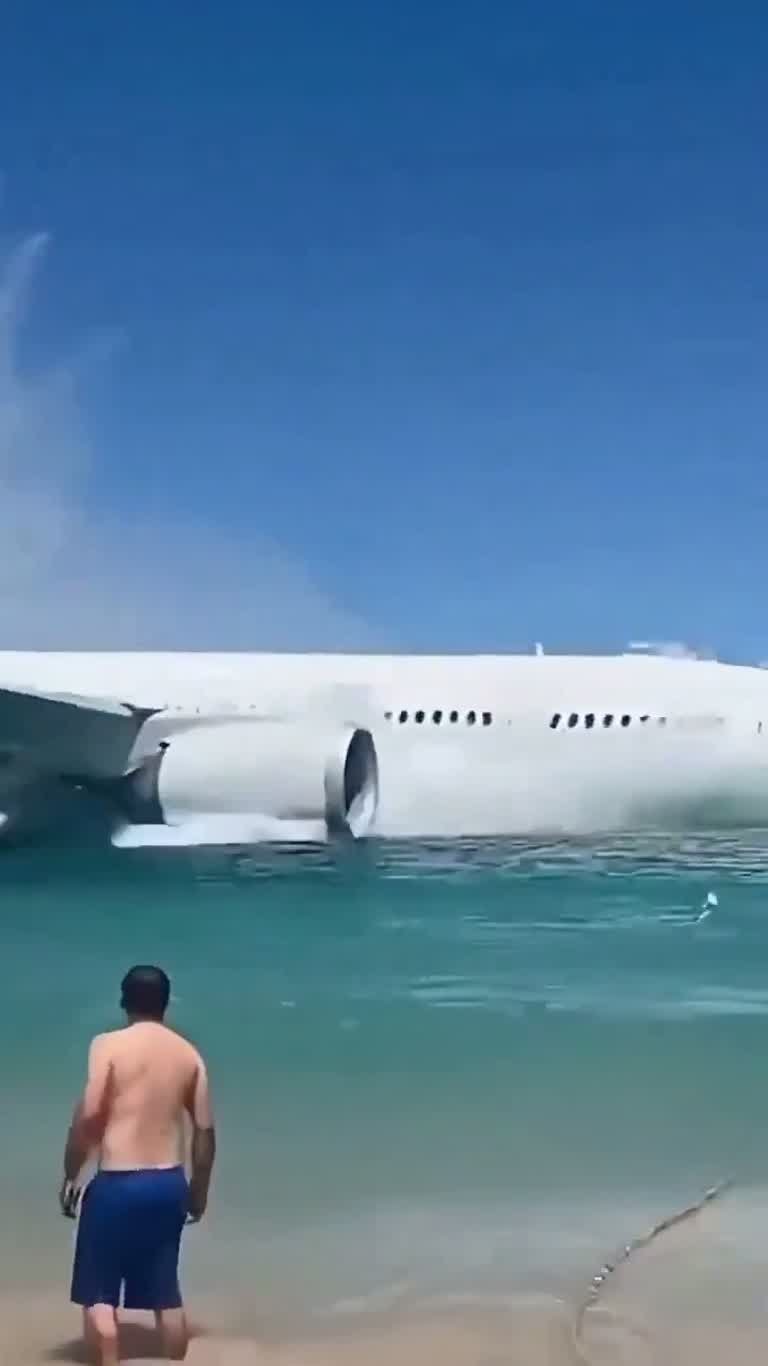 Aircraft Appears in the Surf as Swimmers Watch From the Beach